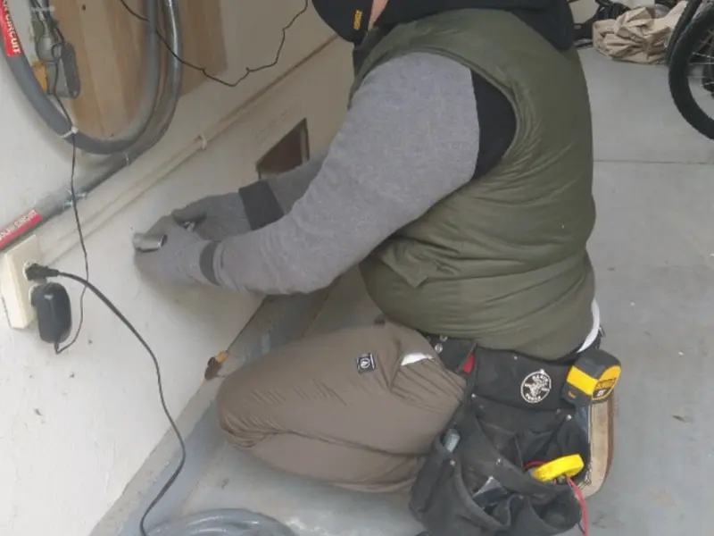 Electrician performing outlet wiring in a Wagoner garage